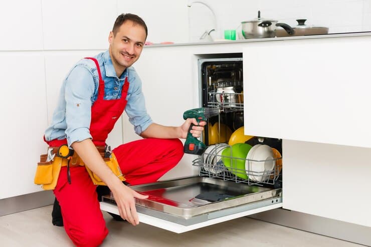 male technician sitting near dishwasher kitchen