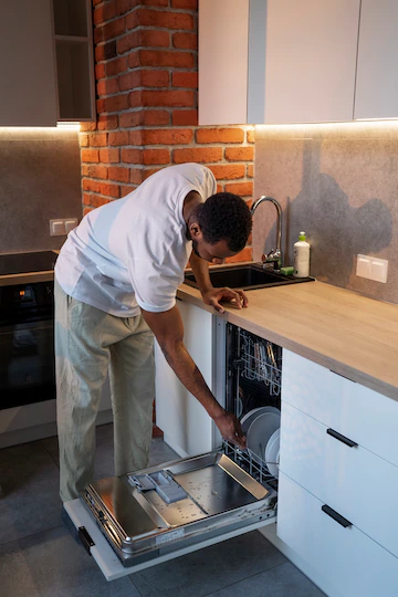 side view man loading dishwasher - sos appliance repairs